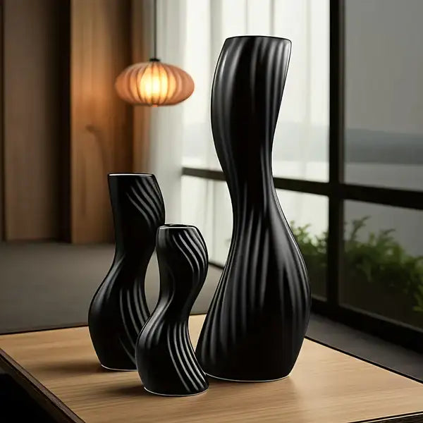 Conjunto de vasos de cerâmica preta com textura canelada e design moderno.